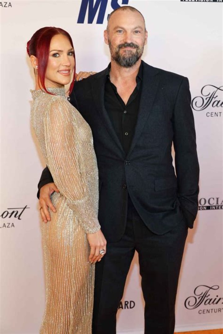Brian Austin Green Cradles Sharna Burgess’ Baby Bump In Cutout White Dress — Photo