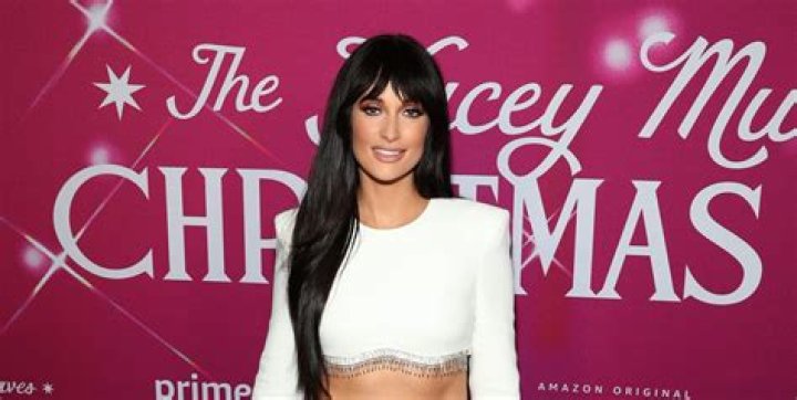 Kacey Musgraves Shows Off Abs In White Crop Top & Mini Skirt For Christmas Show Launch – Pics