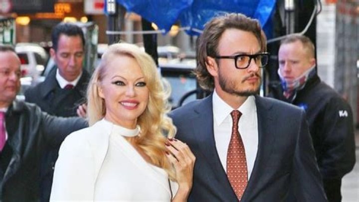 Pam Anderson Looks Stunning In High-Slit White Gown On The Arm Of Son Brandon In NYC