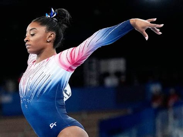 Simone Biles Rocks A Floral Bikini & Strikes A Pose On The Beach